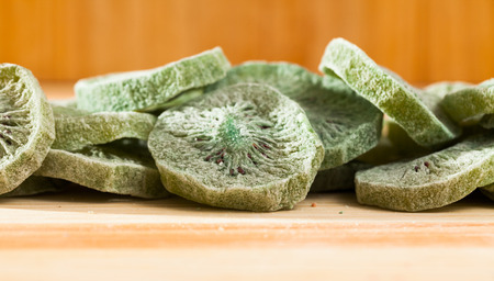 Tasty dessert â slices of dried kiwi on wooden backgroundの写真素材