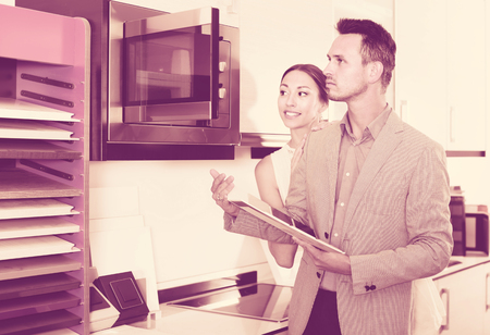 middle class satisfied family selecting modern kitchen furnitureの写真素材