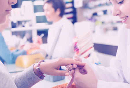 Nail technicians performing manicure procedure in beauty salonの写真素材