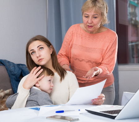 Woman is outraged of utility bills and quarreling with her mother at home.の写真素材