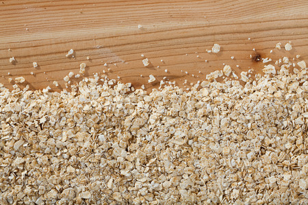 Natural background - organic oat-flakes on wooden surfaceの写真素材