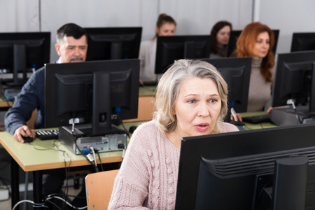 Portrait of focused mature woman during computer classes at university of third ageの写真素材