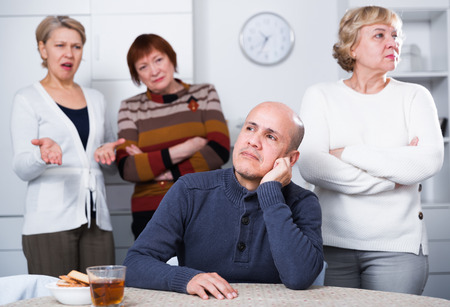 Mature women are confrontating with their friend at home.の写真素材