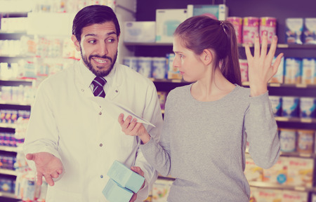 Portrait of woman client who is dissatisfied of recommended medicines in pharmacy.の写真素材
