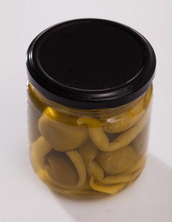 Glass jar with delicious whole olives marinated with hot pepperの写真素材