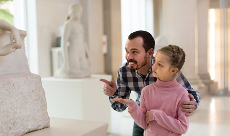 Positive man and small girl explanation ancient statues in museumの写真素材