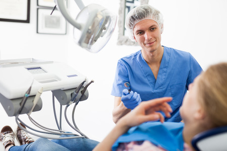 Young woman on dental checkup in modern dentist officeの写真素材