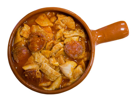 Top view of Spanish Callos of tripe braised in sauce with chopped chorizo and chickpeas served in clay cazuela. Isolated over white backgroundの写真素材