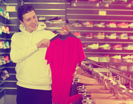 Tennis man is looking on modern shirt for sport in storeの写真素材