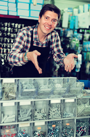 Smiling seller man in hardware store is trading goods for construction in harware store.の写真素材