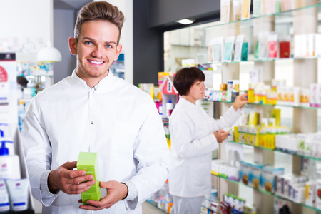 Profesional smiling young team of pharmaceutist and technician working in chemist shopの写真素材