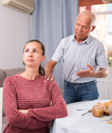 Mature father soothes adult daughterの写真素材