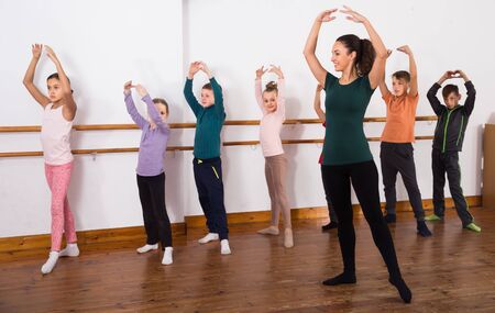 diligent boys and girls primary school age rehearsing ballet dance in studioの写真素材