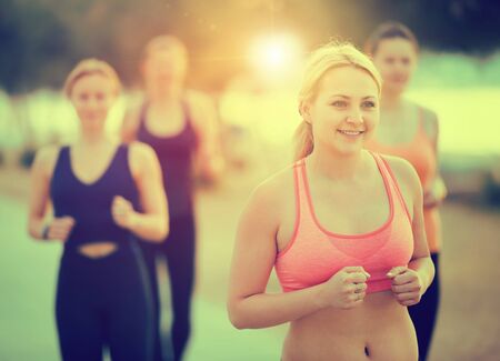 Positive young women during racewalking training in daytimeの写真素材