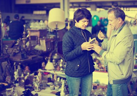Mature couple choosing vintage artifacts at fleamarket outdoorの写真素材