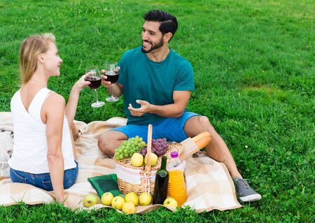 Couple are talking sitting and drinking wine in time picnic outdoor.の写真素材