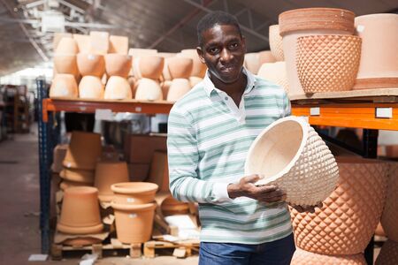 Portrait of African American man choosing pots for flowers and trees in gardening marketの写真素材
