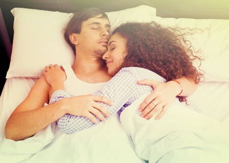 Portrait of young adults hugging each other while sleepingの写真素材