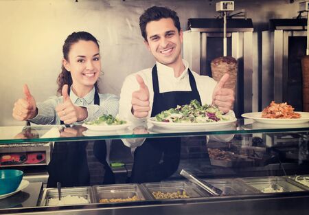 Smiling young restaurant staff posing at kebab counter and smilingの写真素材