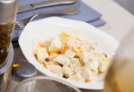 Tasty salad with meat, pineapple, fresh orange and eggs served on white plateの写真素材