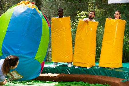People as bowling pins in an amusement park on a summer sunny day
