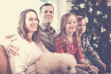 Family of four spending Christmas time together at homeの写真素材