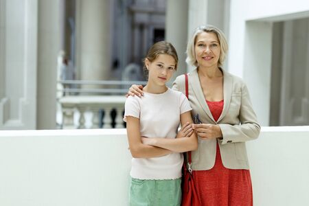 Teenage girl and mature woman observing exhibition in historical museumの写真素材