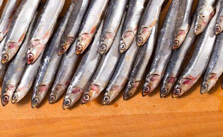 Fresh raw anchovies served on wooden surfaceの写真素材