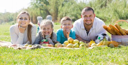 Portrait of cheerful family of four people lying in the parkの写真素材