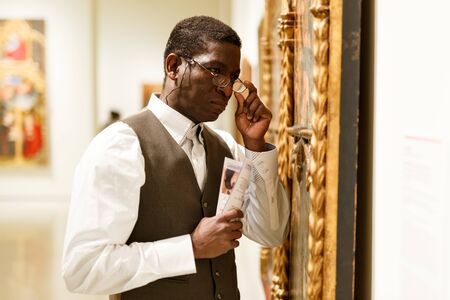 African man looking at exhibit on exposition of historical museumの写真素材
