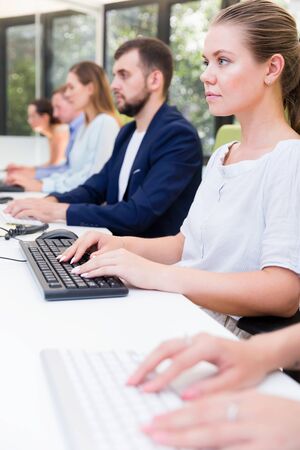 Side view of focused employees during daily work in modern co-working spaceの写真素材