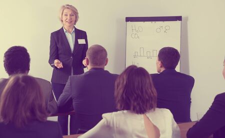 Confident mature businesswoman presenting new business project to members of her international teamの写真素材