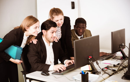 Team of managers developing strategy together in modern office with laptop