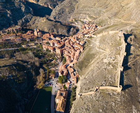 Aerial view of old mansions and castle walls of Albarracin surrounded by stony hills, Aragon, Spainの写真素材