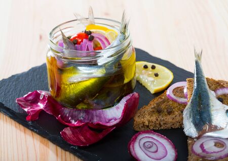 Homemade pickling pilchards with onions, beets, peppers and marinade of vinegar, lemon, olive oil and sea salt. Served on black bread with onions.の写真素材