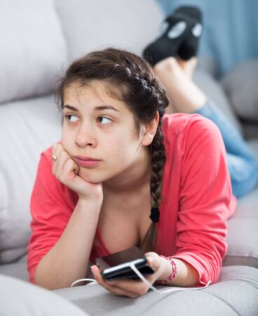 Young girl feeling distressed and lonely alone at homeの写真素材