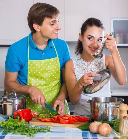 Happy russian man and woman standing near table with vegetablesの写真素材