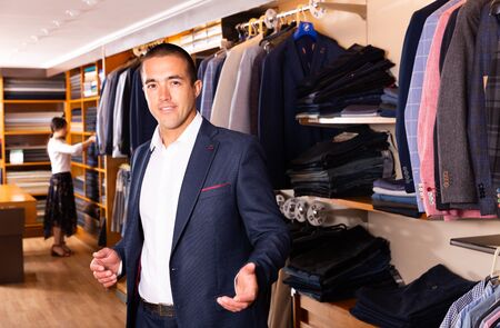 Portrait of male client choosing classic jacket in the mallの写真素材