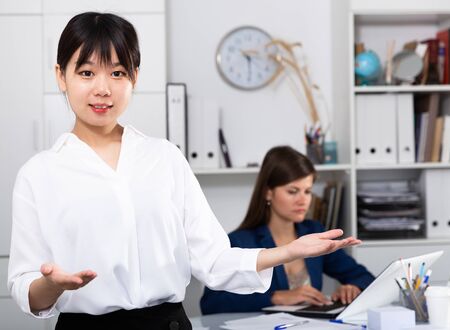 Asian girl manager of international company greeting guests in officeの写真素材
