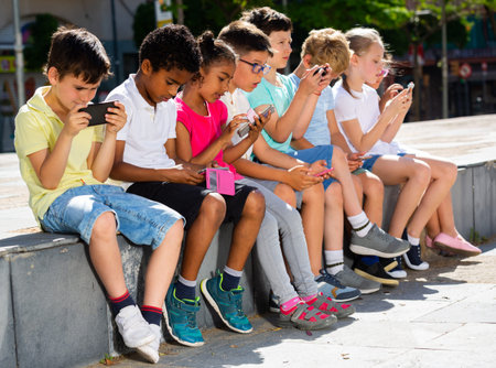 Children are playing on smartphone in the playground