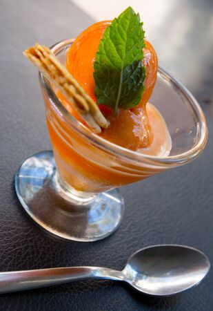 Image of tasty cold   orange ice cream served at glass cup with wafer and mintの写真素材