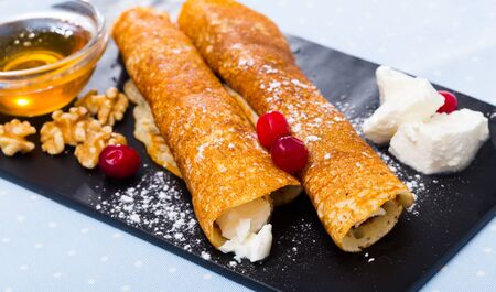 Traditional Bulgarian Palachinka crepes stuffed with brinsen cheese and walnut served with honeyの写真素材