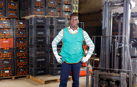 Portrait of afro warehouse worker with loader in warehouse of mandarins