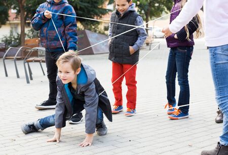 Boy smiling passes through the tangled ropeの写真素材
