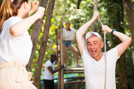 Group of people passing zipline one by one at adventure park