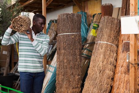 Portrait of African American man buying decorative fencing at garden material warehouseの写真素材