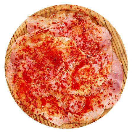 Top view of Galician-style Lacon - sliced dried pork shoulder with olive oil and paprika served on wooden plate. Isolated over white backgroundの写真素材