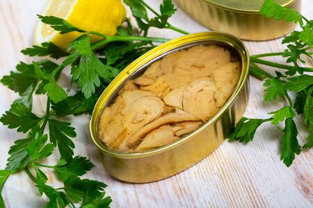 Open can of tuna fillets in sunflower oil on wooden tableの写真素材