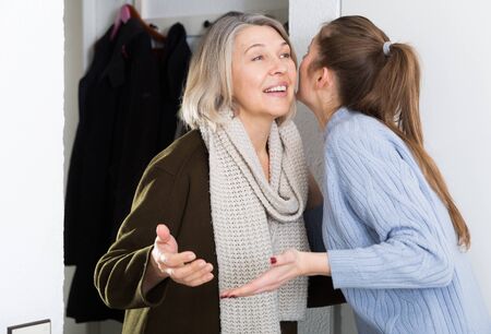 Daughter meets mother in the hallway at homeの写真素材