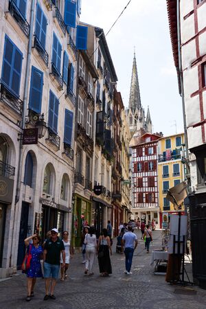 BAYONNE, FRANCE - JULY 17, 2019: View of traditional old narrow street with towering above it Gothic spire of Saint Mary Cathedralのeditorial素材